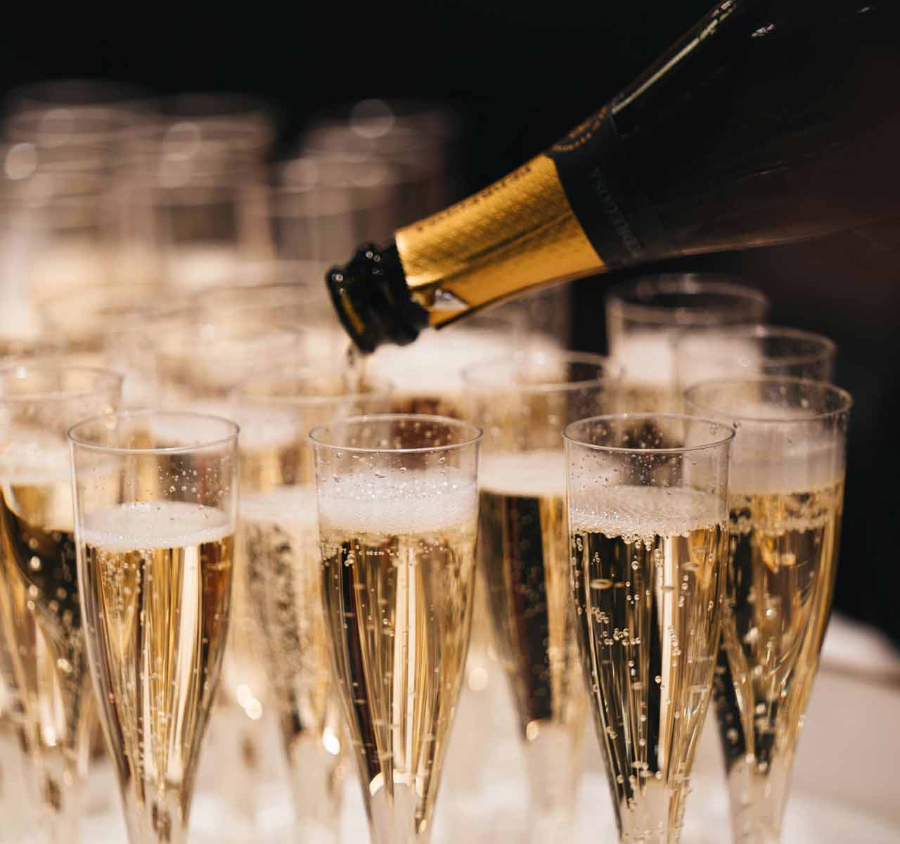 Champagne being poured by mobile bar staff for guests on arrival at a wedding in Boroughbridge, North Yorkshire